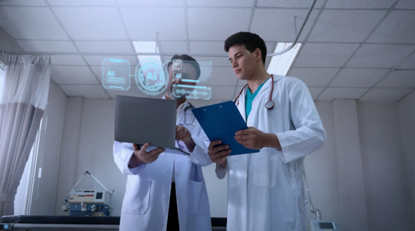 Male-presenting healthcare workers looking at a laptop with an "AI" hologram hovering above the screen