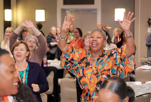 Woman cheering next to other women at conference