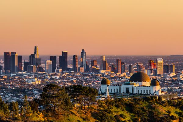 photo of los angeles skyline with griffith park observatory in foreground