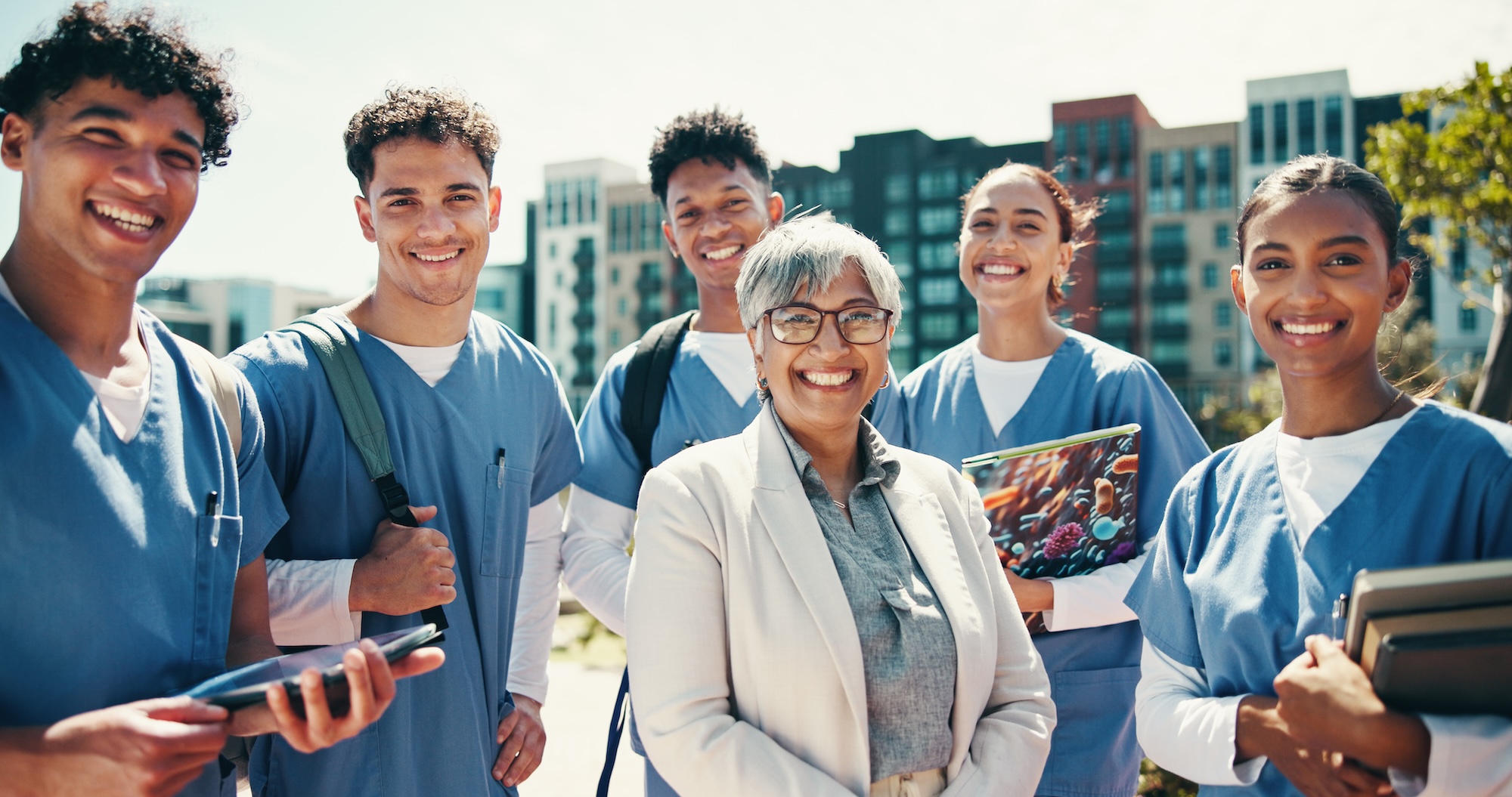 nursing student, portrait and professor with people in outdoor for college, healthcare and teacher. Scholarship, university and doctors with intern group on hospital campus for smile and education